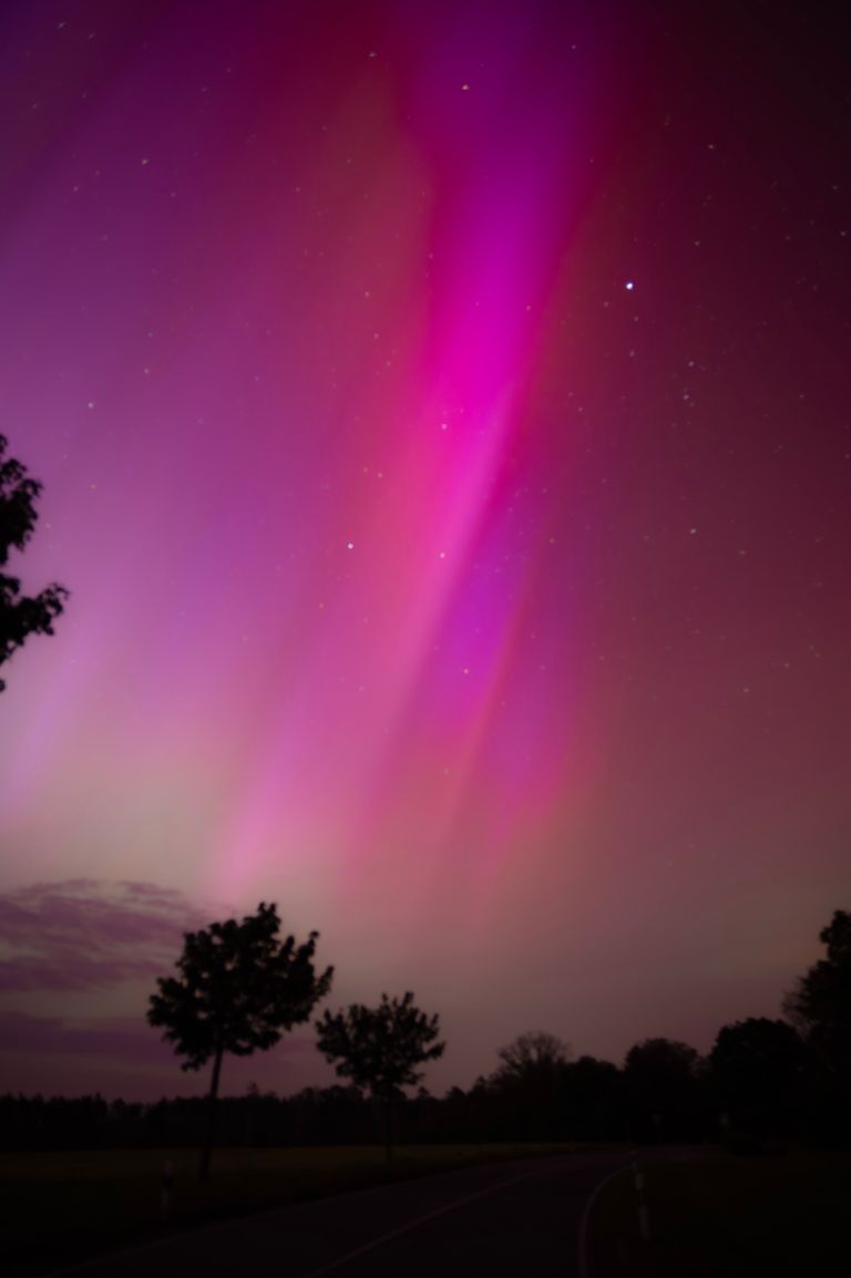 Vibrant aurora borealis illuminating the night sky in Leipzig, Germany.